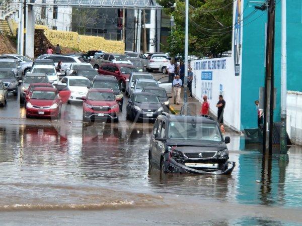 Dos vehículos varados por inundación en Avenida Independencia y Escudero
